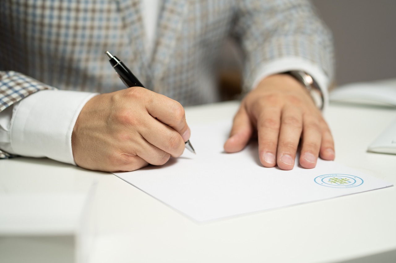 Manos de hombre firmando un documento