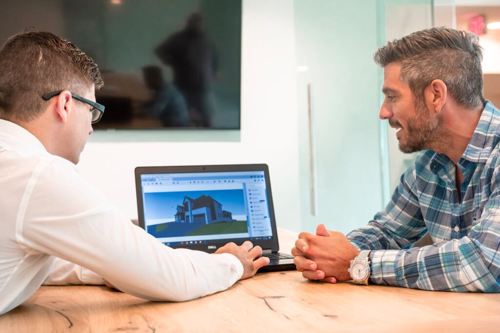 Dos hombres haciendo un render 3D en el portátil