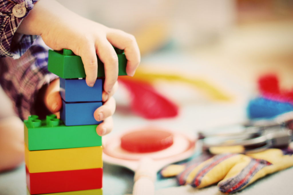 Manos de niño montando piezas para mejorar su desarrollo cognitivo