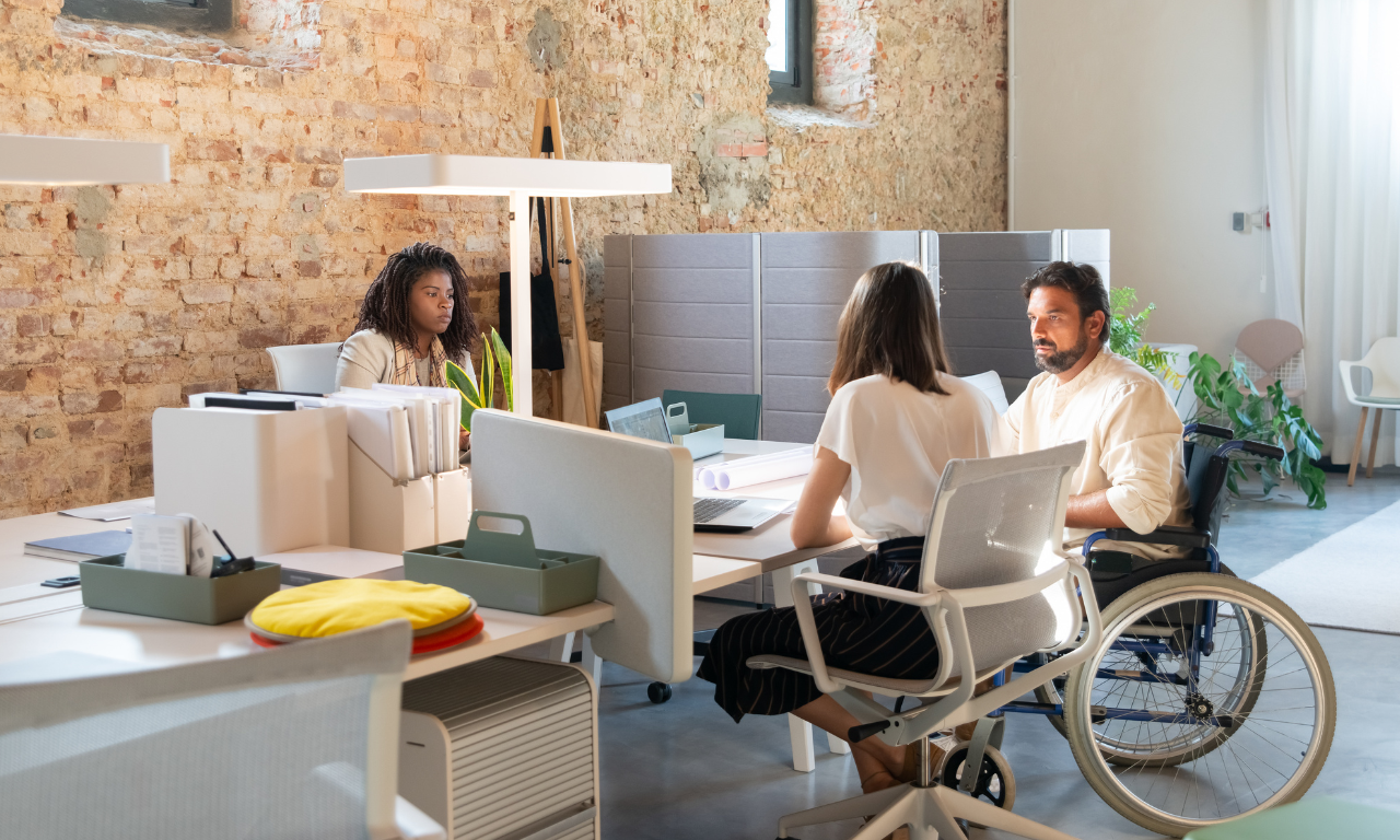 Tres empleados de una empresa, uno de ellos en silla de ruedas.